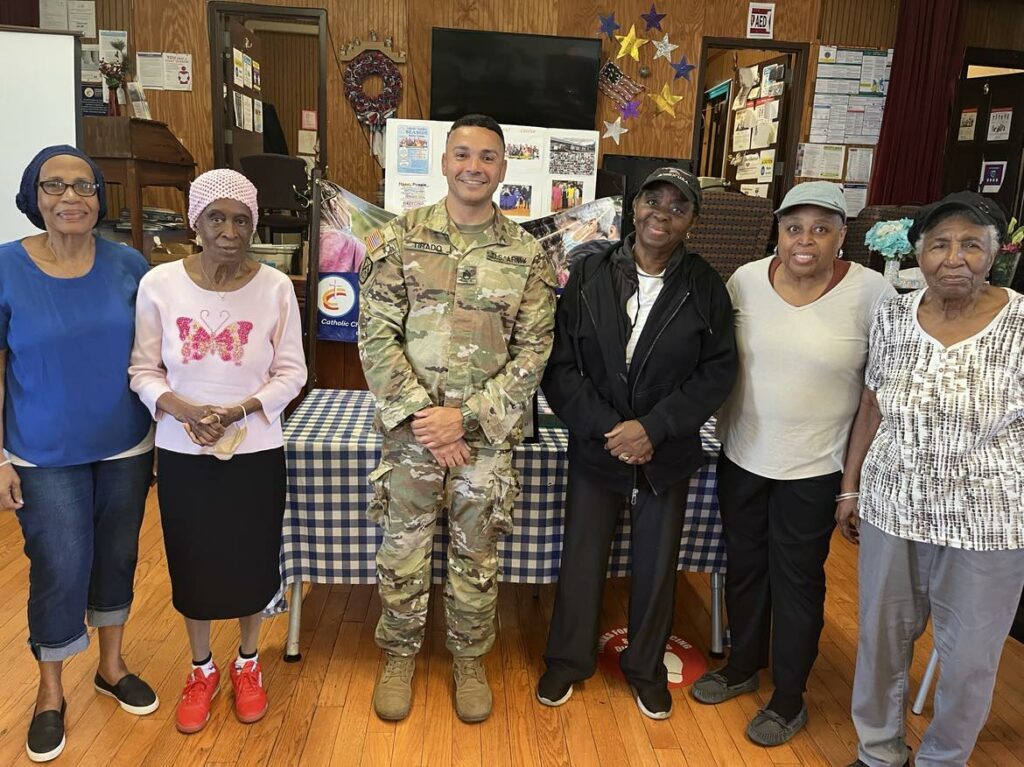 Five members of an older adult center photographed with a uniformed officer.